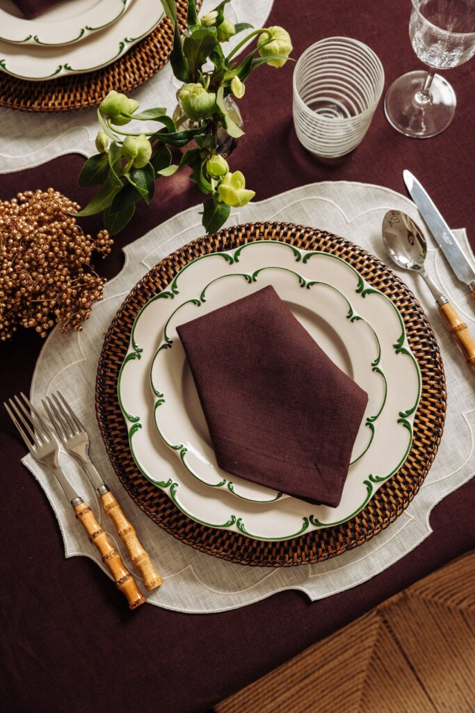 Traditional country place setting in  colours of burgundy, tan and cream, with bamboo handle flatware. Sheridan Interiors, luxury interior design firm serving Cornwall, Ottawa, Brockville and Eastern Ontario.