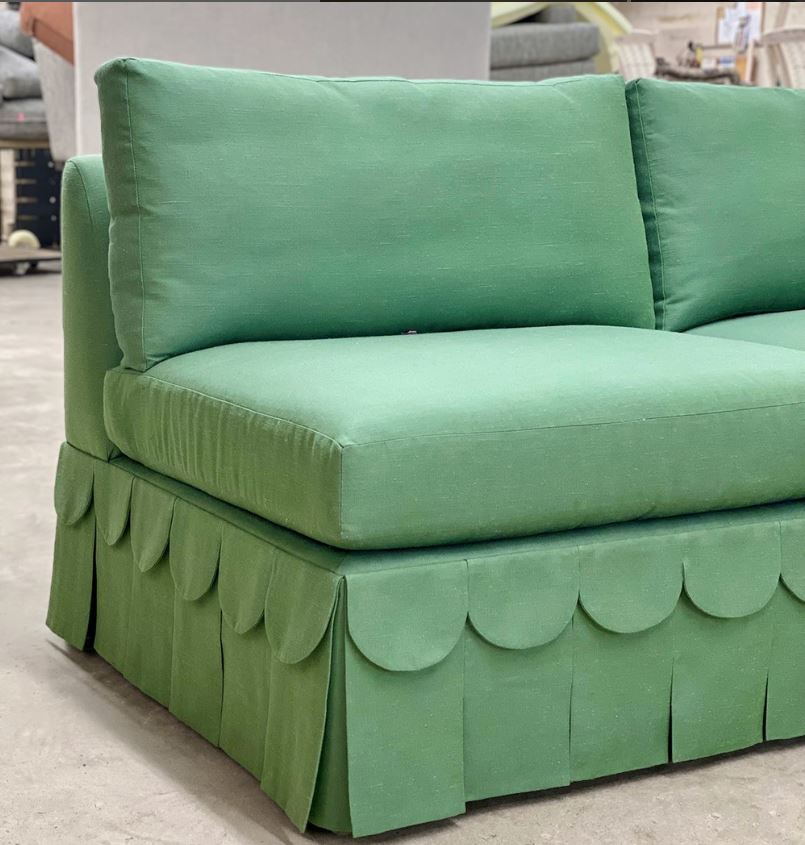 Custom-made green armcless sofa with box-pleat skirt overlayed with additional scalloped skirting.  Luxury custom upholstery for Ottawa, Cornwall, Ontario and surrounding areas. 