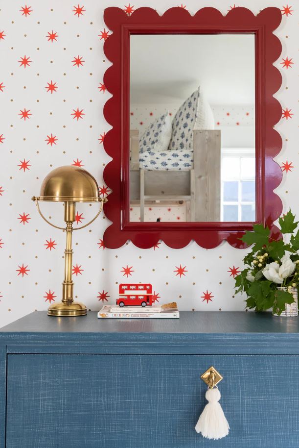 Deep red scalloped mirror over blue chest.  Luxury interior designer serving Ottawa, Cornwall Ontario and surrounding areas.
