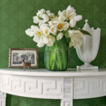 white console table, dark green geometric wallpaper, green glass vase with white flowers and other white accessories, interior design, interior decor, sheridan interiors inc.